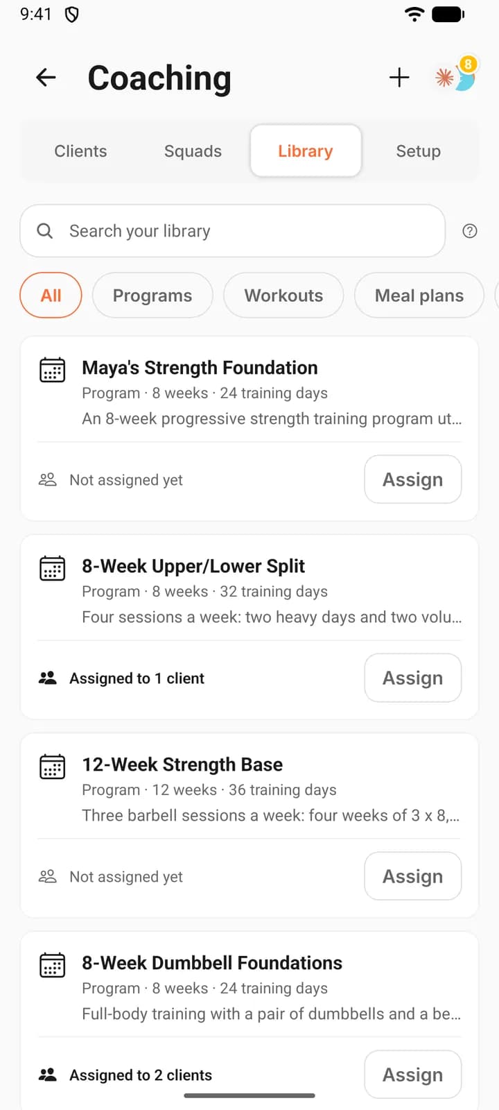 The Library tab of Coaching on a phone: a search field, filter chips (All, Programs, Workouts, Meal plans and more off to the right), and program cards that show their size, how many clients are on them and an Assign button.